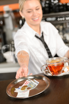 Attractive waitress taking tip in bar EUR