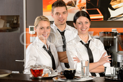 Three server posing in uniform in cafe