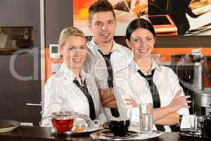 Three server posing in uniform in cafe