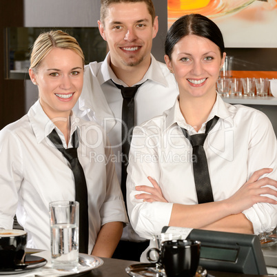 Three server posing in uniform in cafe