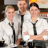 Three server posing in uniform in cafe