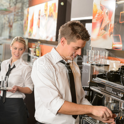 Young waiter and waitress working in bar