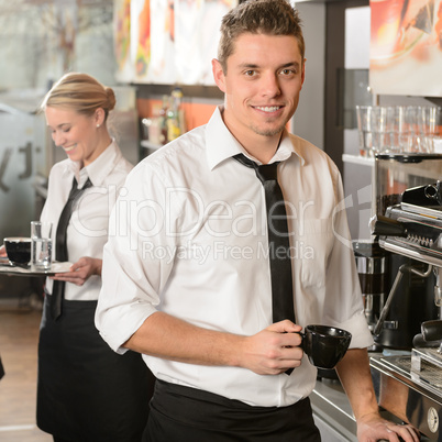 Handsome waiter making coffee espresso machine