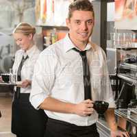 Handsome waiter making coffee espresso machine