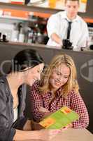 Young female customers reading menu in pub
