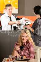 Happy female customer drinking espresso in cafe