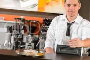 Handsome smiling male waiter giving receipt CZK
