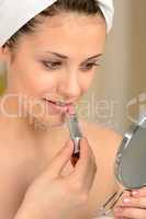 Young teenager girl using lipstick handheld mirror