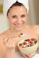 Joyful girl eating muesli for breakfast