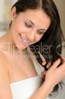 Cheerful young woman styling her hair