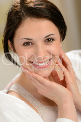 Delighted young woman stroking her face