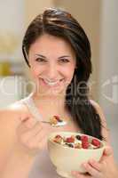 Attractive young woman eating bowl of cereal