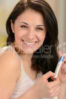 Cheerful young woman holding pregnancy test