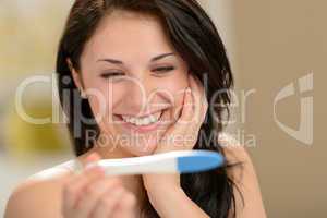 Delighted woman holding pregnancy test