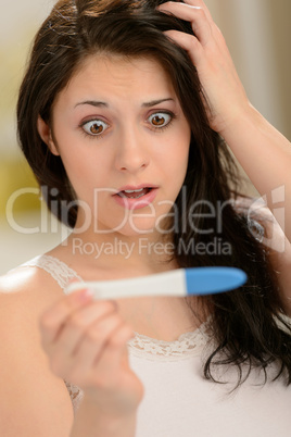 Worried woman looking at pregnancy test