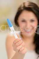 Excited young woman showing pregnancy test