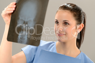 Female doctor examining X-ray picture with skull