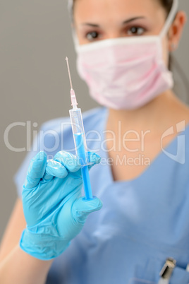 Female nurse with syringe in face mask