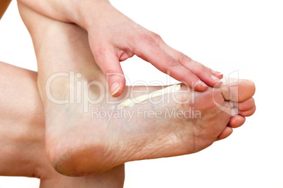 A woman putting cream on her foot