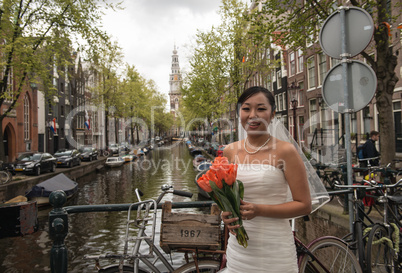 AMSTERDAM, APR 30: Bride waits for Groom over city canal, April