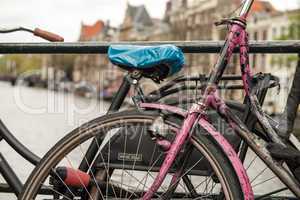 Amsterdam, Netherlands. Colourful bike over a bridge and city ch