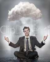 Businessman meditating under cloud