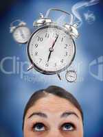 Woman looking up at ringing alarm clocks