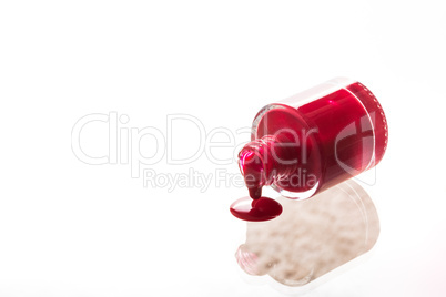 Spilled red nail polish bottle