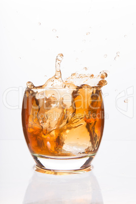 Tumbler glass with brown alcohol