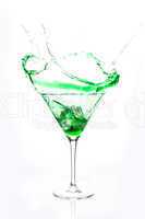 Cocktail glass with green alcohol splashing