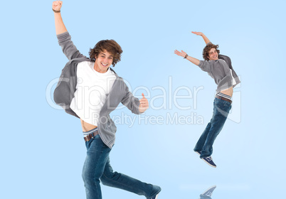 Two of the same teenage boy jumping for joy