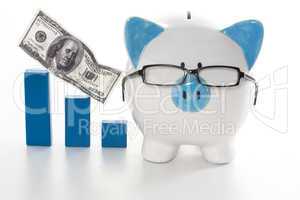 Blue and white piggy bank wearing glasses with blue graph model