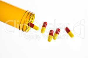 Jar of medicine spilling capsule tablets