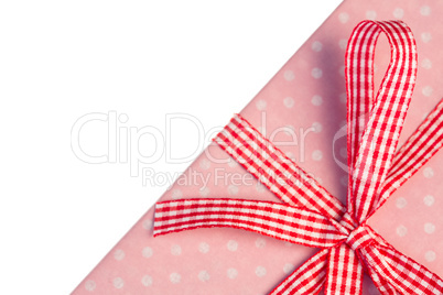 Pink gift wrapped present with gingham ribbon