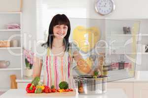 Smiling woman making dinner using hologram interface