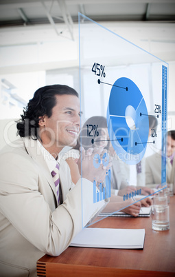 Smiling businessman looking at blue pie chart interface