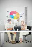 Three business people using colorful pie chart interface