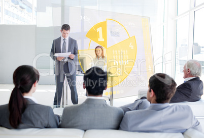 Business people listening and looking at yellow pie chart interf
