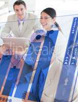 Overview of cheerful colleagues looking at blue chart futuristic