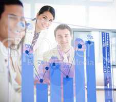 Smiling business workers looking at blue chart interface