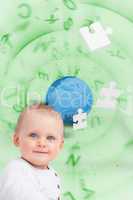 Portrait of a baby with planet and jigsaw pieces green backgroun