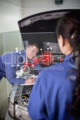 Smiling mechanic looking up at colleague with a futuristic inter