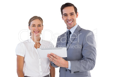 Smiling co workers using a tablet pc