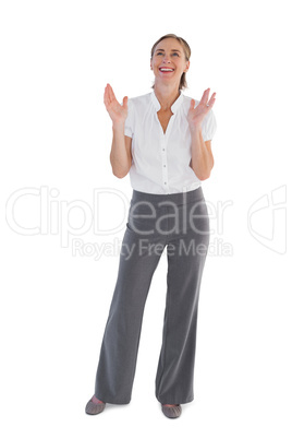 Cheerful businesswoman standing with raised hands