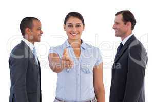 Businesswoman giving her hand in the middle of two businessmen