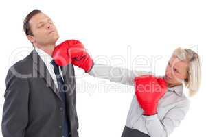 Businesswoman hitting colleague with boxing gloves