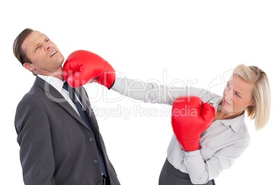 Businesswoman hitting colleague with her boxing gloves