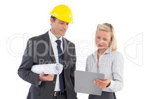 Architects with hard and plans looking at clipboard