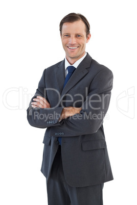 Charismatic smiling businessman standing with arms crossed
