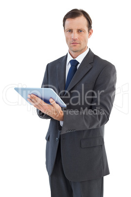 Serious charismatic businessman holding a tablet computer